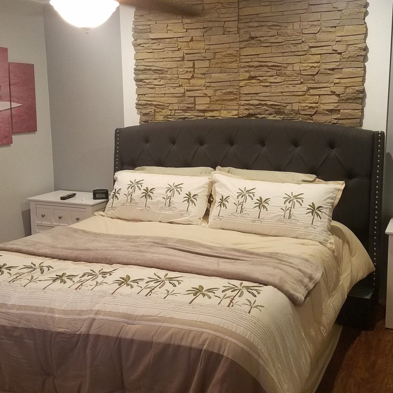A DIY bedroom accent wall made using Desert Sunrise Stacked Stone panels.