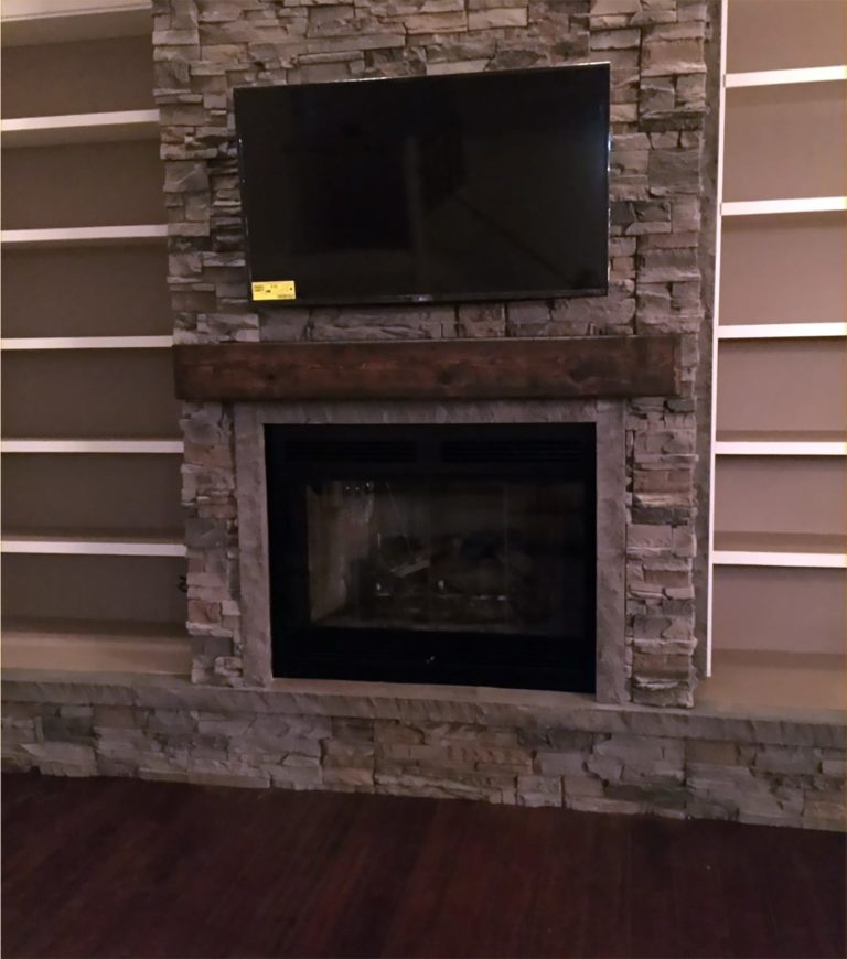 A faux stone fireplace surround designed using our Kenai Stacked Stone panels.