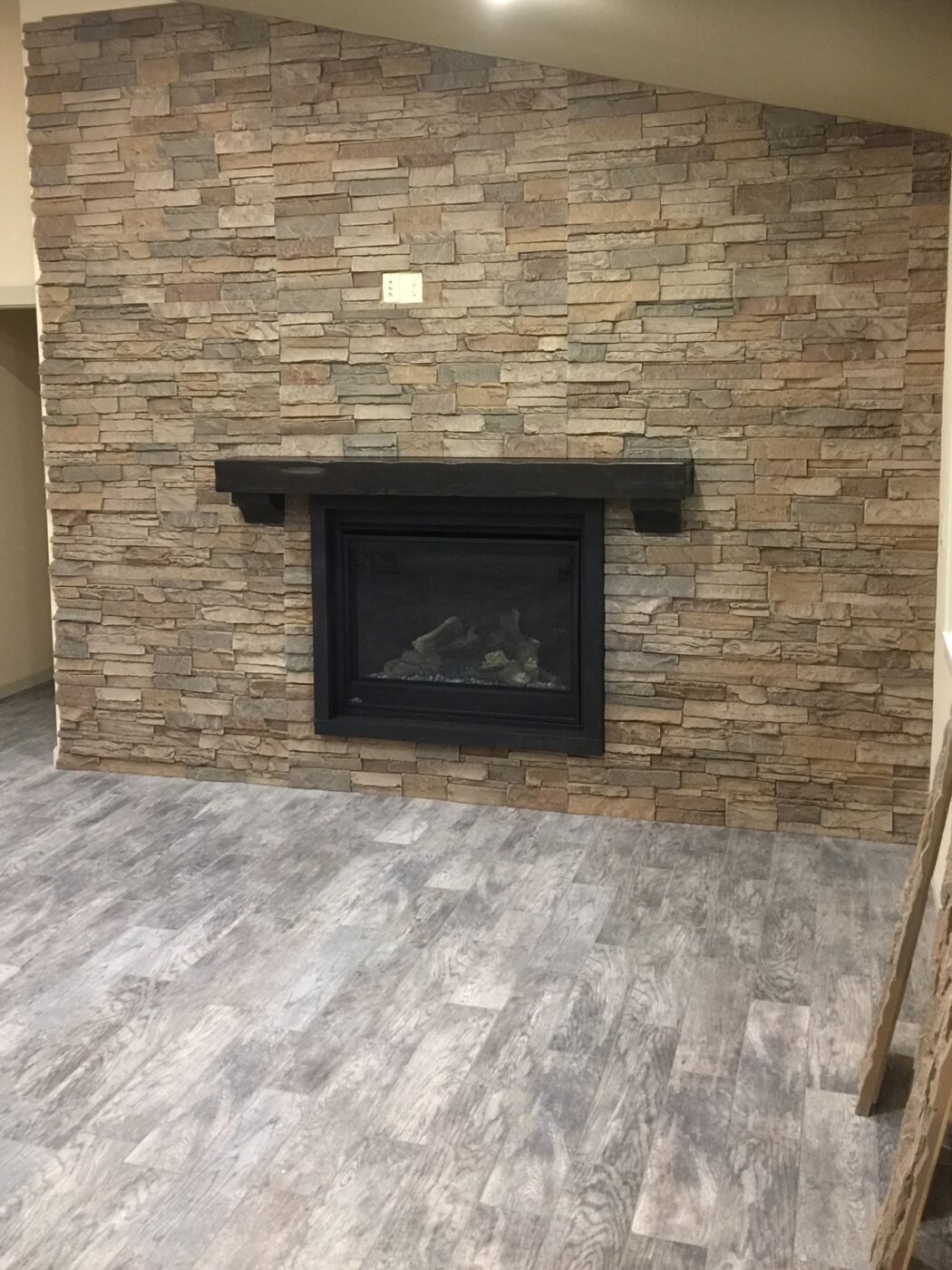A fireplace accent wall project that uses our Kenai Stacked Stone panels.
