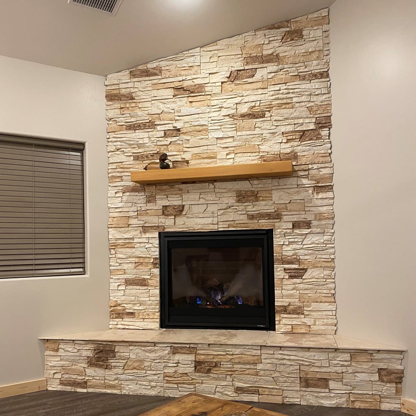 Vanilla Bean corner fireplace design with stacked stone