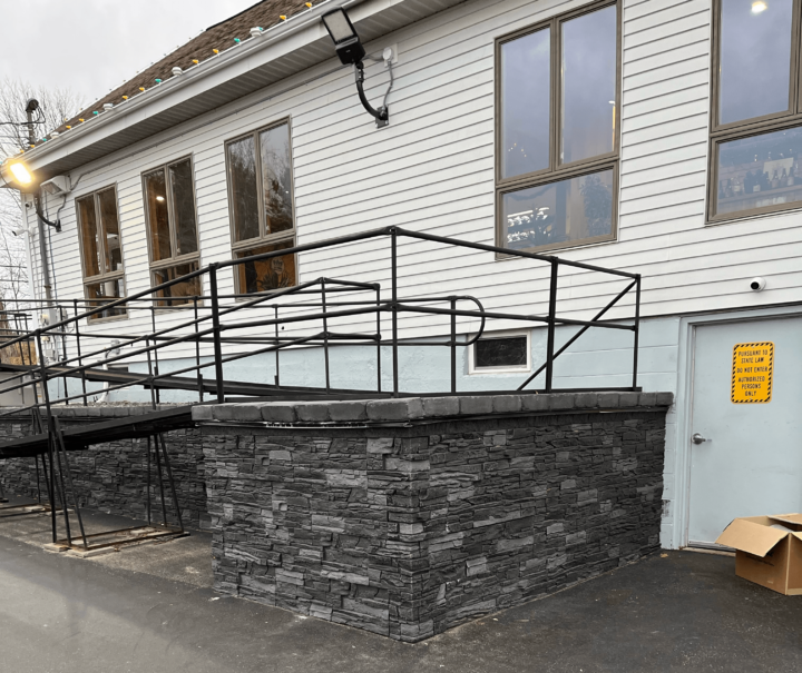 Iron Ore faux stone used as wheelchair ramp wainscoting outside of a building.