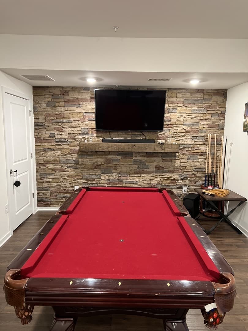 A pool room with a Desert Sunrise Stacked Stone accent wall.