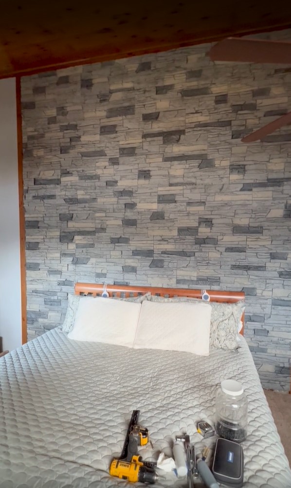 A DIY bedroom accent wall project using Northern Slate Stacked Stone panels.
