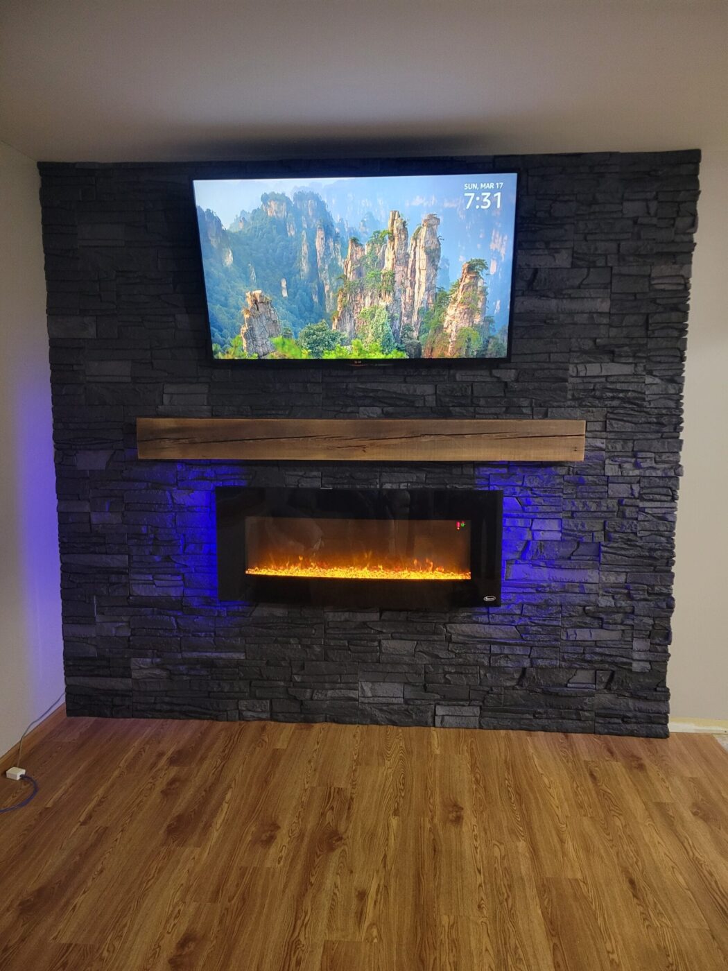 A DIY electric fireplace surround that uses GenStone's Iron Ore Faux Stone panels.