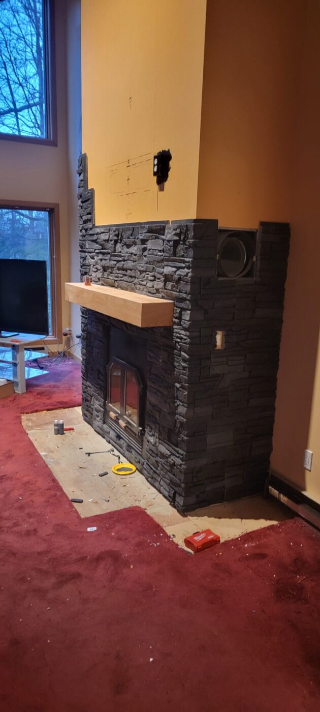 The installation process of a fireplace surround design using GenStone's Iron Ore faux stone panels.