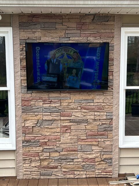 An exterior TV accent wall made using GenStone's Desert Sunrise faux stone.