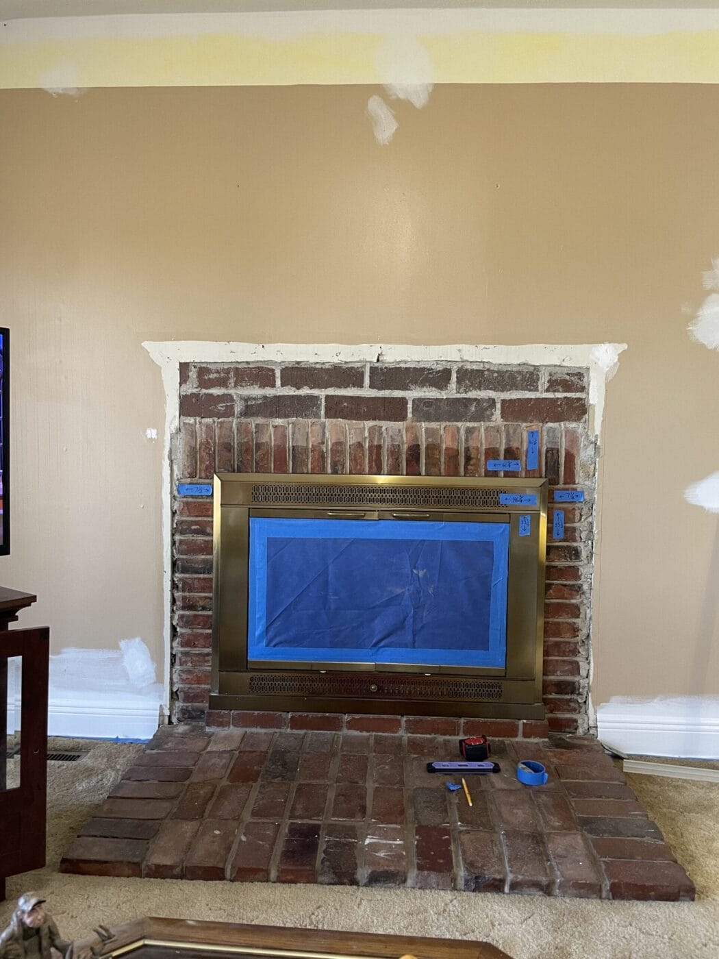Before the completion of a fireplace surround project that uses GenStone's Desert Sunrise faux stone panels over brick.