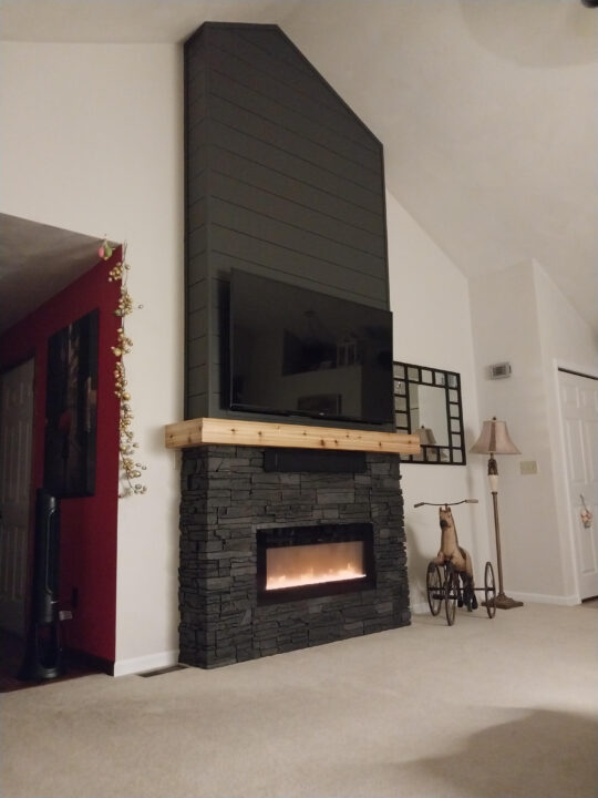 A DIY electric fireplace wall project made using GenStone's Iron Ore Stacked Stone.