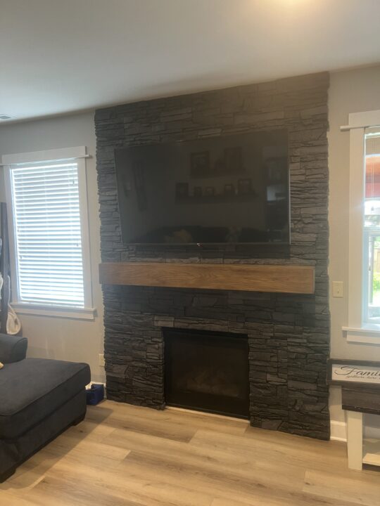 A DIY fireplace surround remodel idea that was brought to life using GenStone's Iron Ore Stacked Stone.