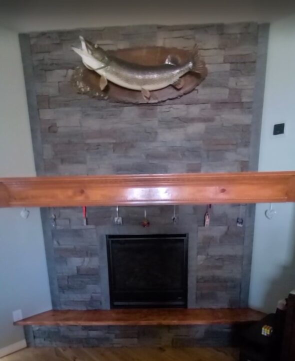 A DIY corner fireplace surround made using GenStone's Kenai faux stone panels.