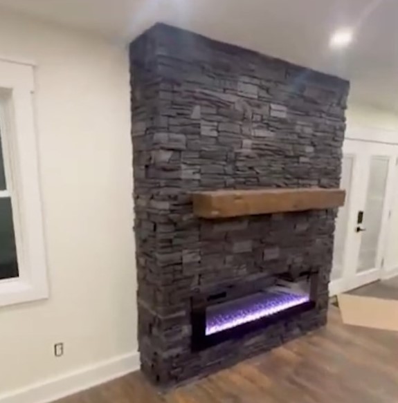 A DIY linear fireplace surround project completed using GenStone's Iron Ore Stacked Stone panels.