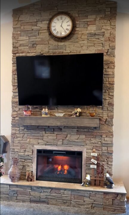 A DIY corner electric fireplace surround project completed using GenStone's Desert Sunrise Stacked Stone panels.