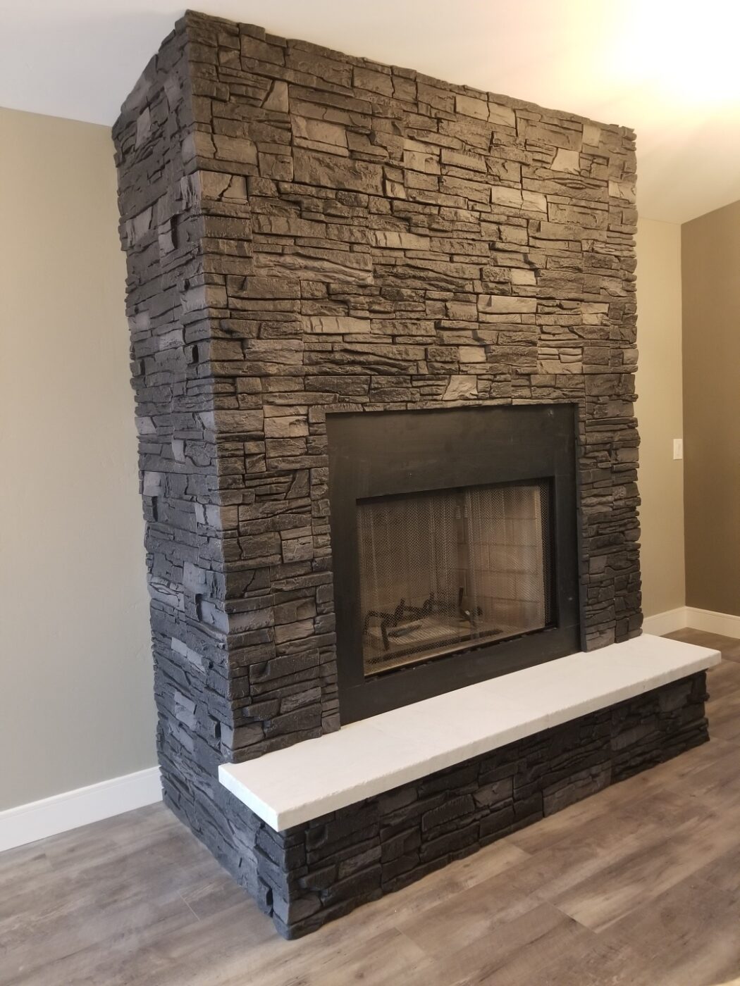 Using GenStone's Iron Ore Stacked Stone panels, Brian created a DIY black slate fireplace.