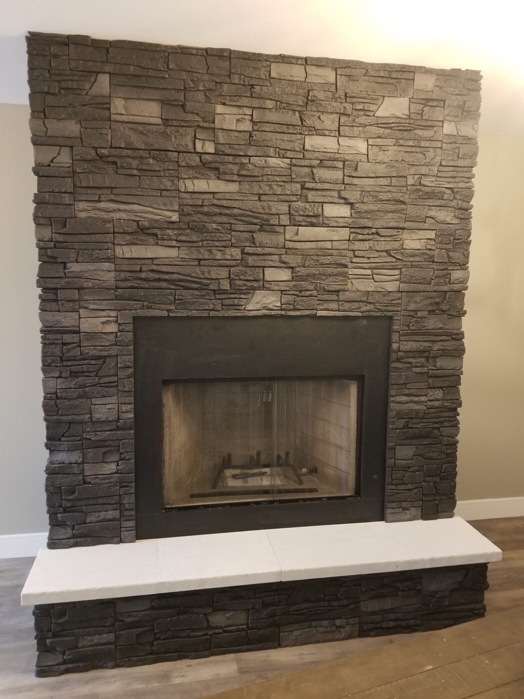 Using GenStone's Iron Ore Stacked Stone panels, Brian created a DIY black slate fireplace.