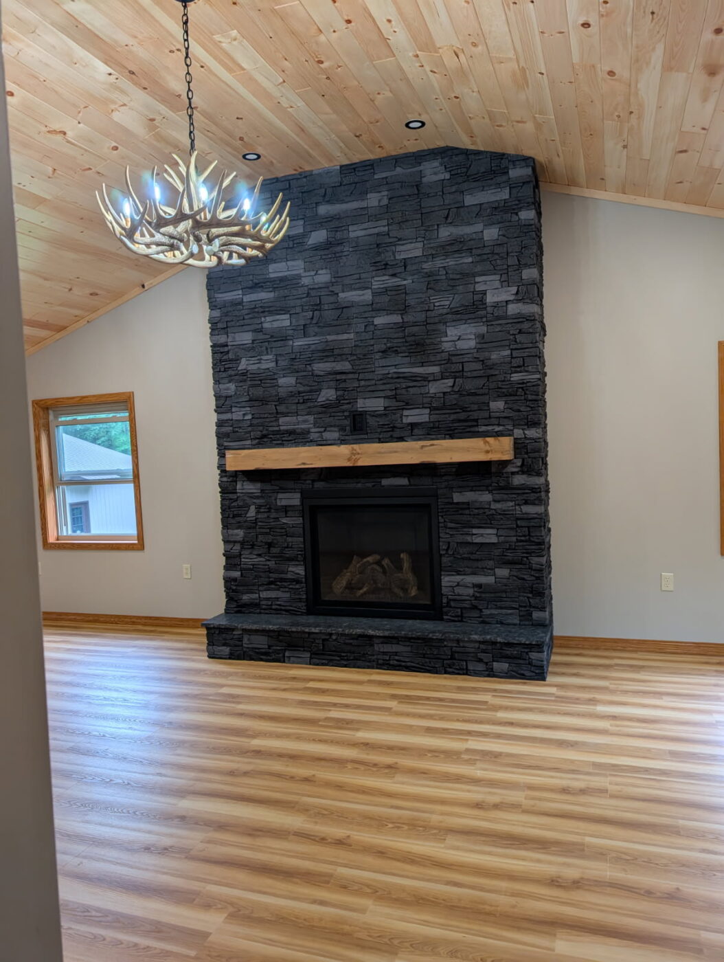 A DIY black stone fireplace that was made using GenStone's Iron Ore Stacked Stone panels.