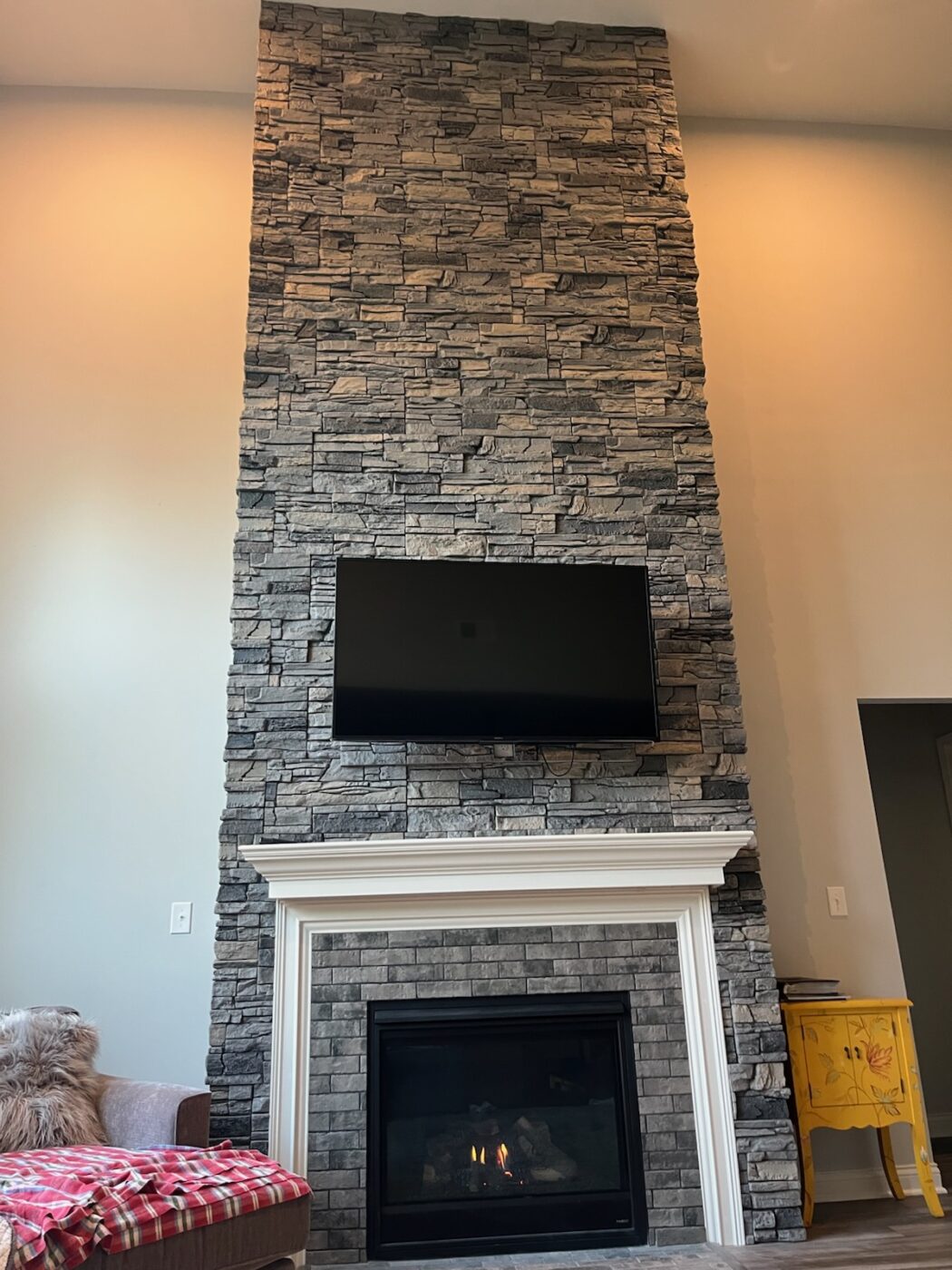 This is a light slate fireplace with a surround crafted using GenStone's Northern Slate Stacked Stone panels.