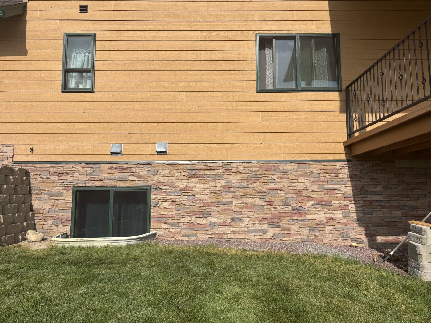 This is a home exterior that has been upgraded with a DIY slate foundation cover up with GenStone's Desert Sunrise Stacked Stone panels.