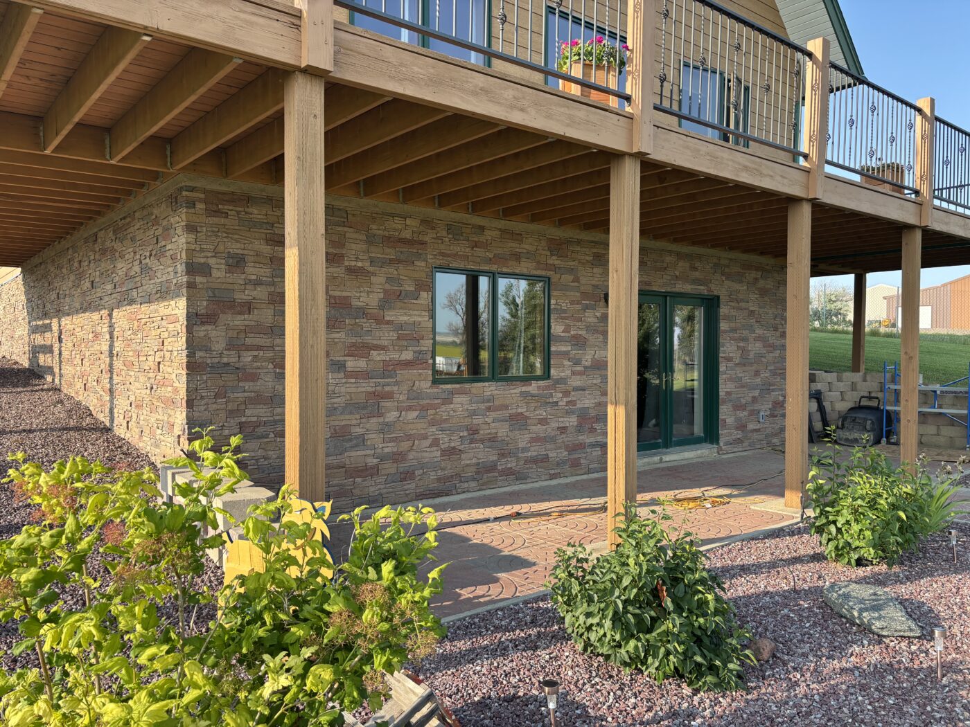 This is a home exterior that has been upgraded with a DIY slate foundation cover up with GenStone's Desert Sunrise Stacked Stone panels.