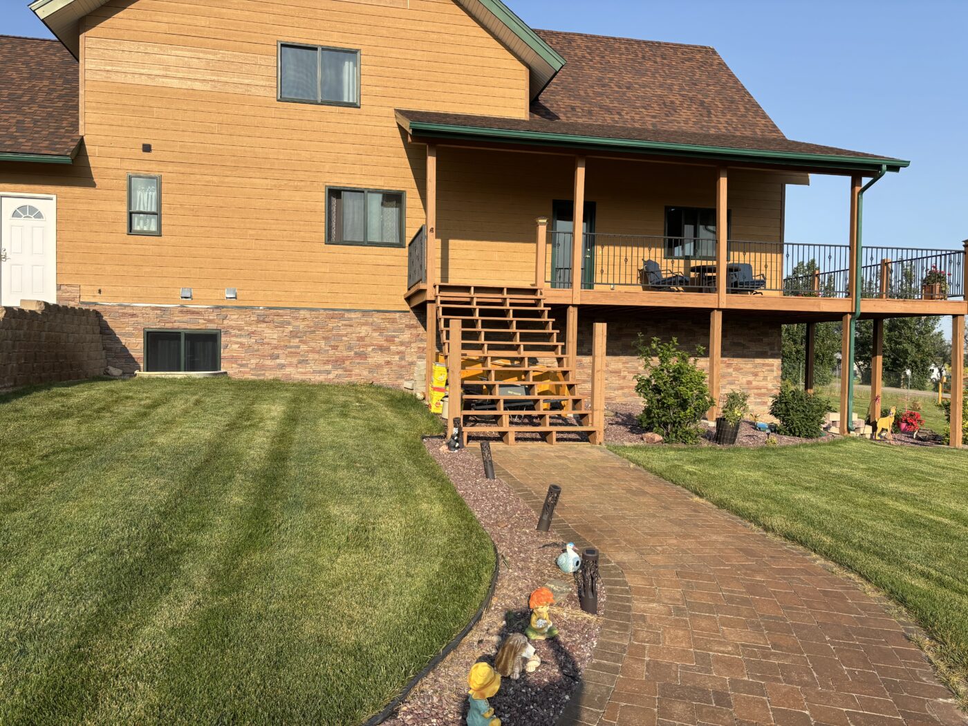 This is a home exterior that has been upgraded with a DIY slate foundation cover up with GenStone's Desert Sunrise Stacked Stone panels.