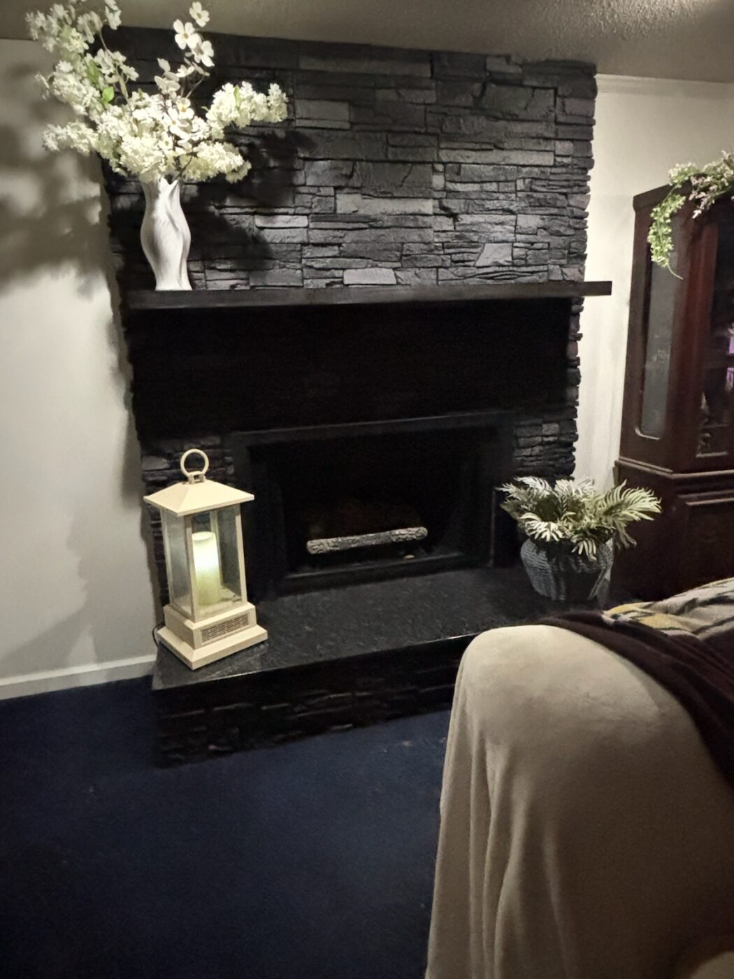 This dark stone fireplace surround was created using GenStone's Iron Ore Stacked Stone panels.