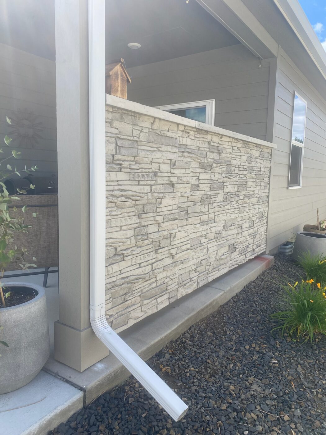 An arctic smoke stone accent wall project on a home's patio that was created using GenStone's Stacked Stone panels.